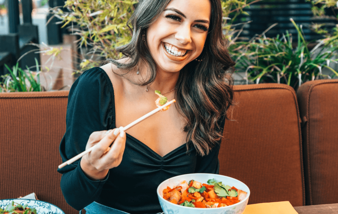 Zadowolona klientka restauracji jedząca zamówione danie